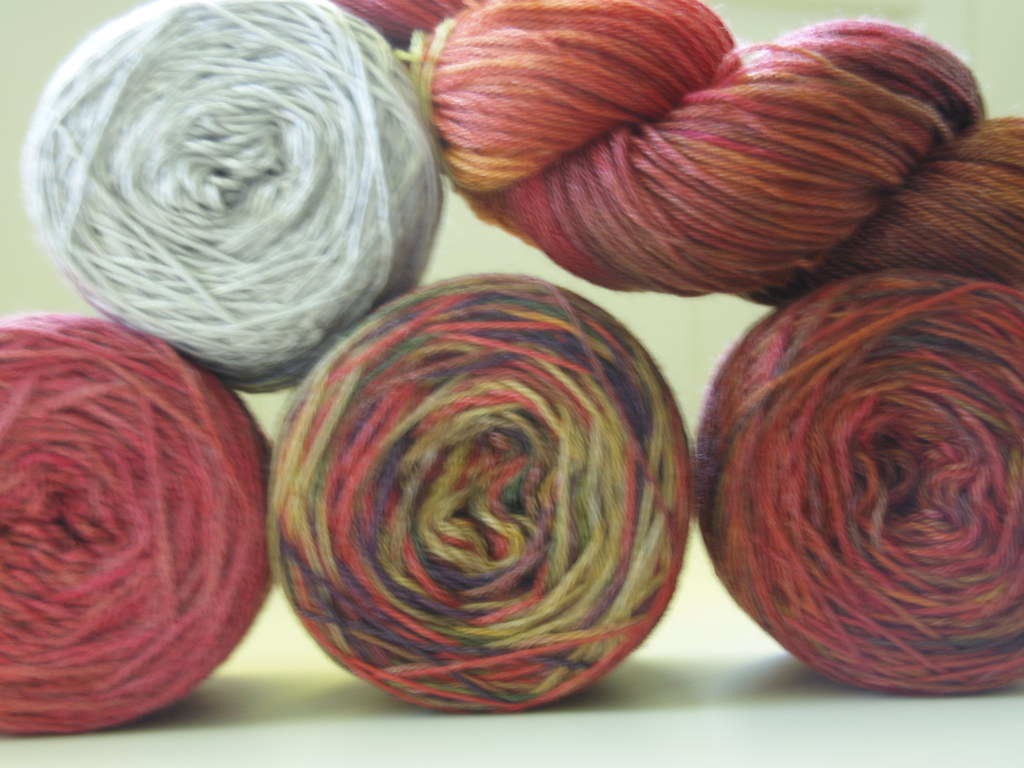 Skeins of hand-dyed wool yarn in warm colors